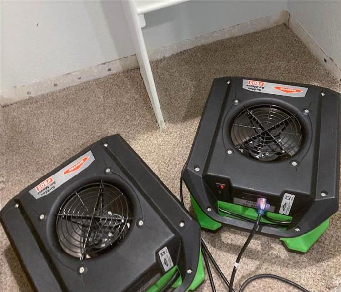 Air movers helping remove moisture from a water damaged home